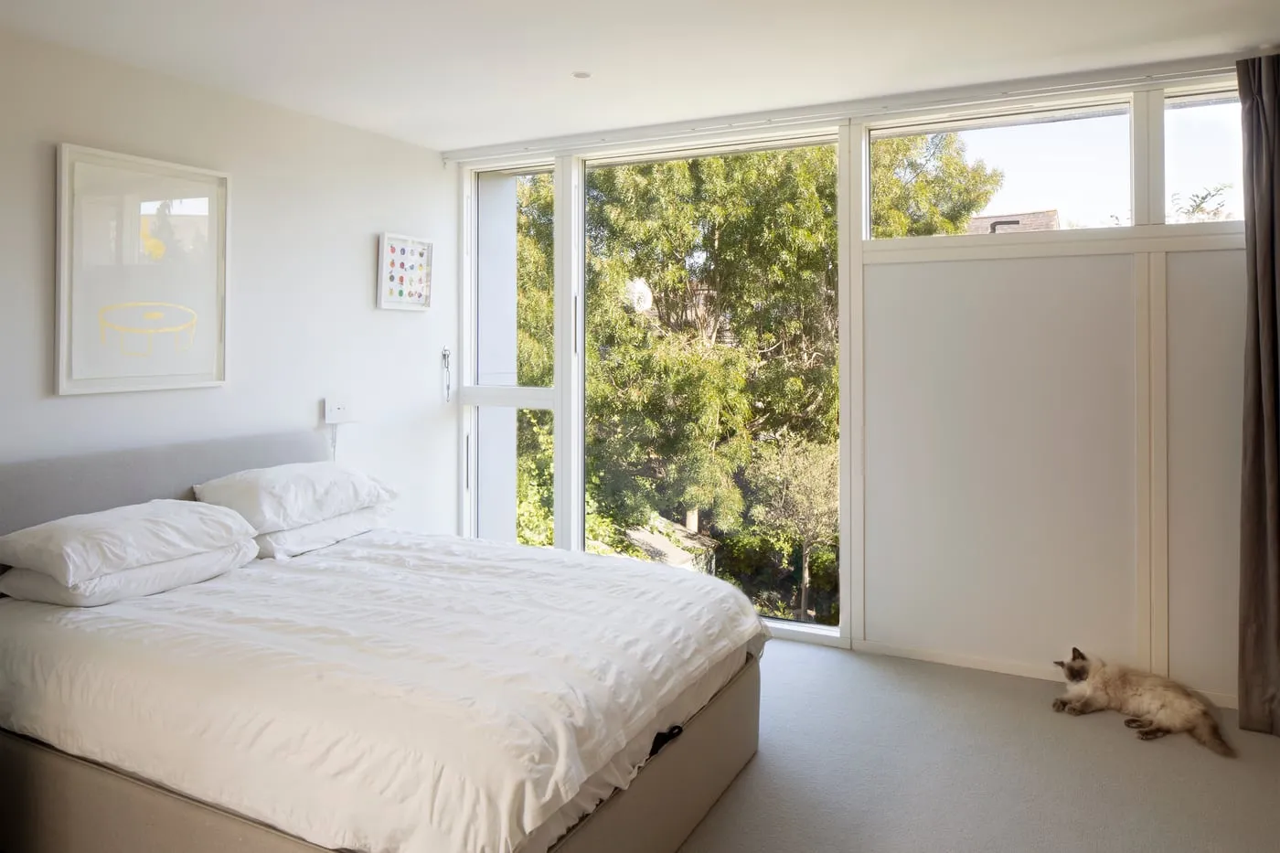Bedroom with full-height glazing onto trees