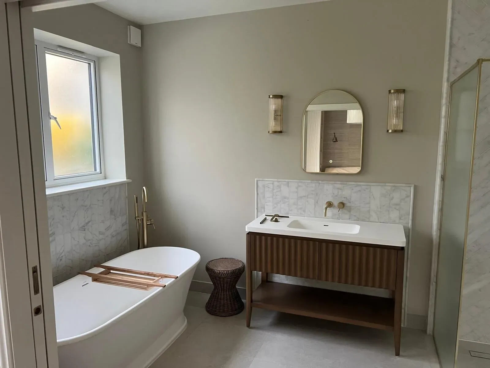 The finished bathroom with herringbone marble tiling in the Fulham period house