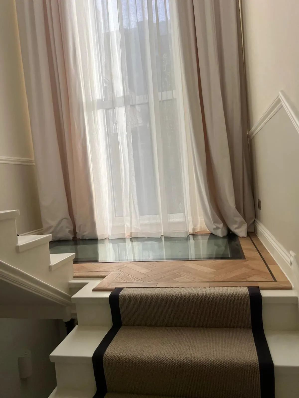 The finished landing with a glass floor skylight bringing daylight down through the house