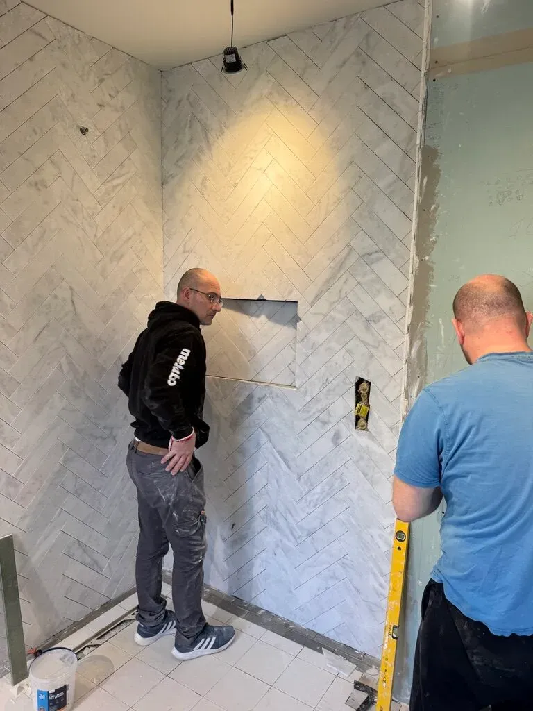 Herringbone marble tiling being set out in the new bathroom
