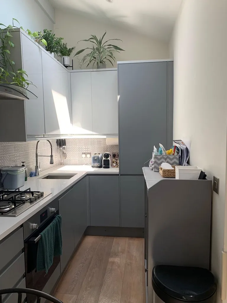 Finished grey handleless kitchen with patterned splashback tiling