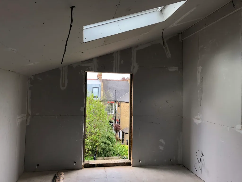 Boarded-out loft room with rooflight and rear opening, showing the finished room shape
