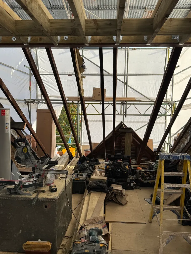 Original loft opened up under a temporary roof, with existing rafters and new floor joists above, during a Wandsworth loft conversion