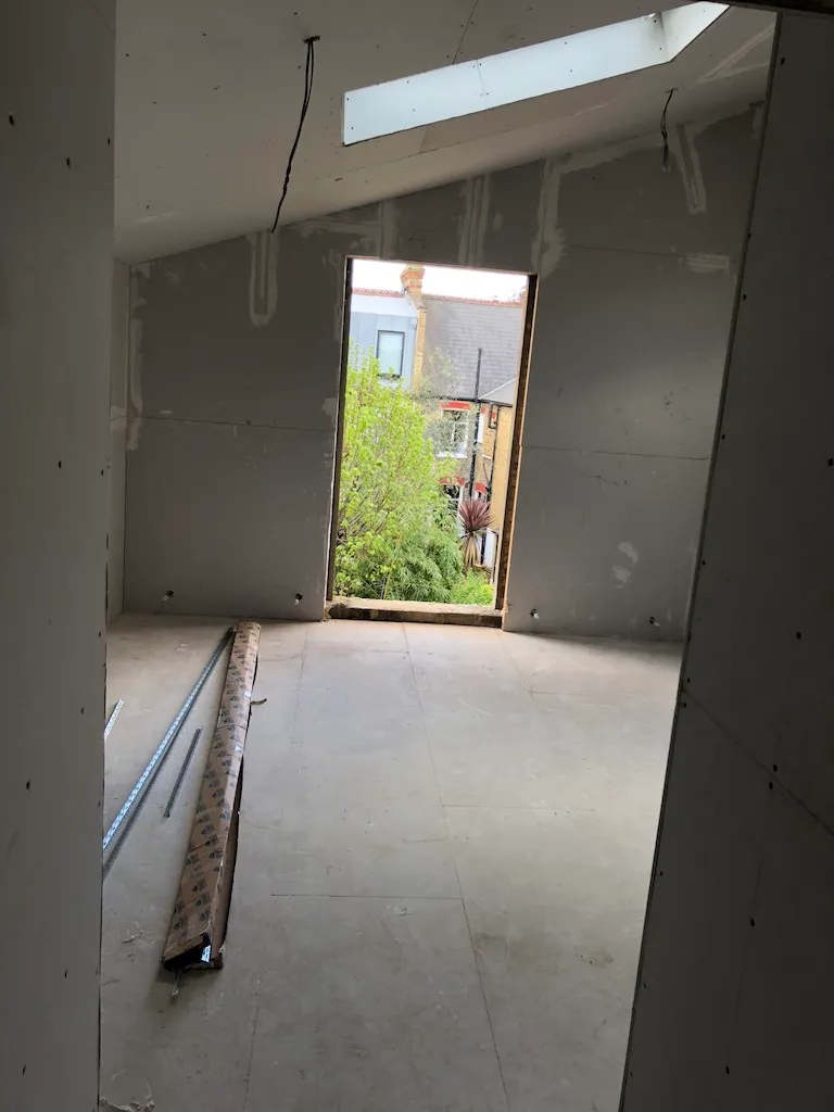 Loft room boarded out with a rooflight and a new door opening framed to the rear elevation
